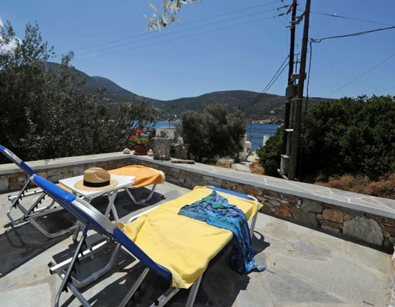 Πλακόστρωτη αυλή με ξαπλώστρες στο Βίλα Βαθύ